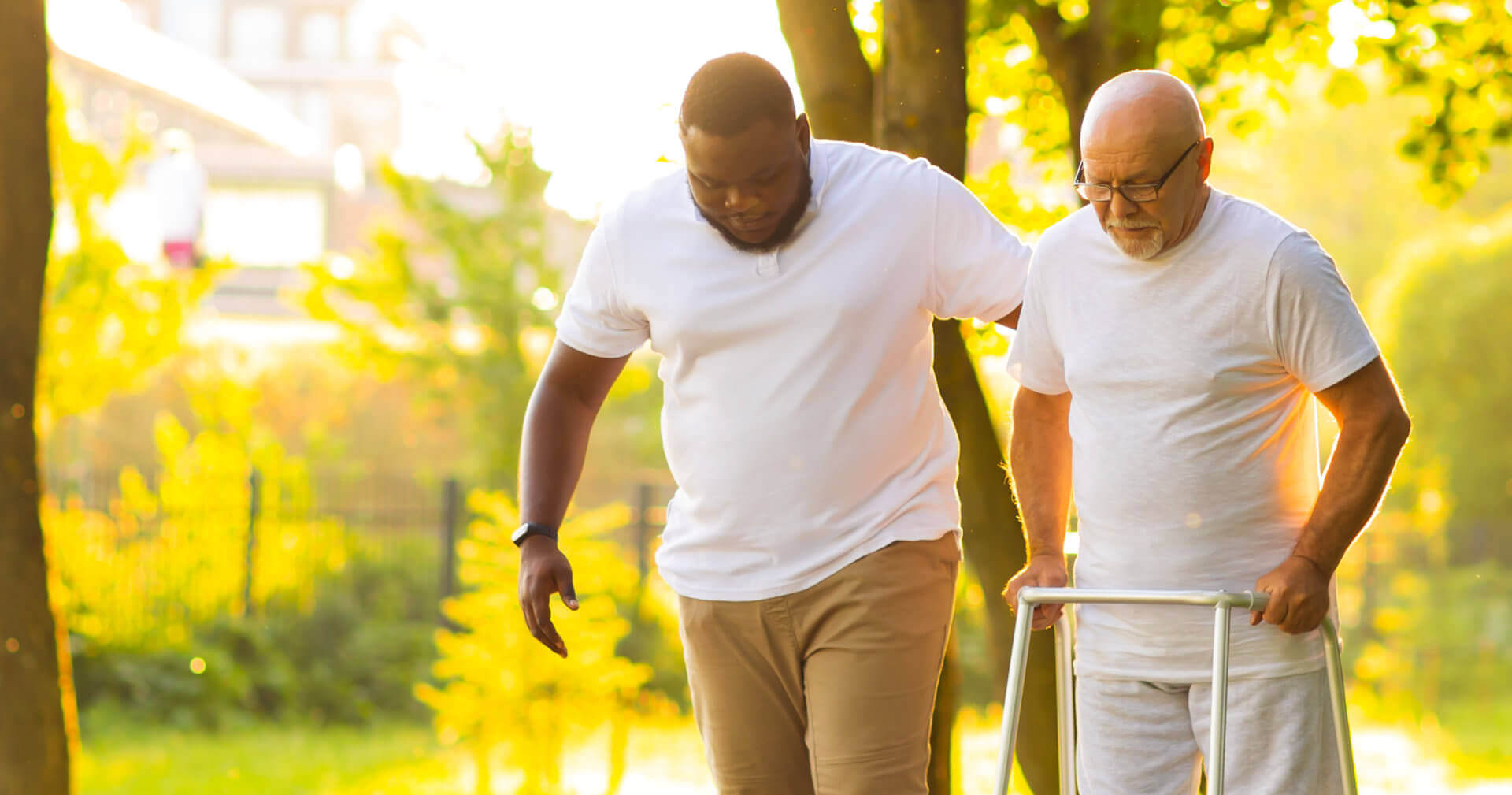 Caregiver assisting a senior man to walk
