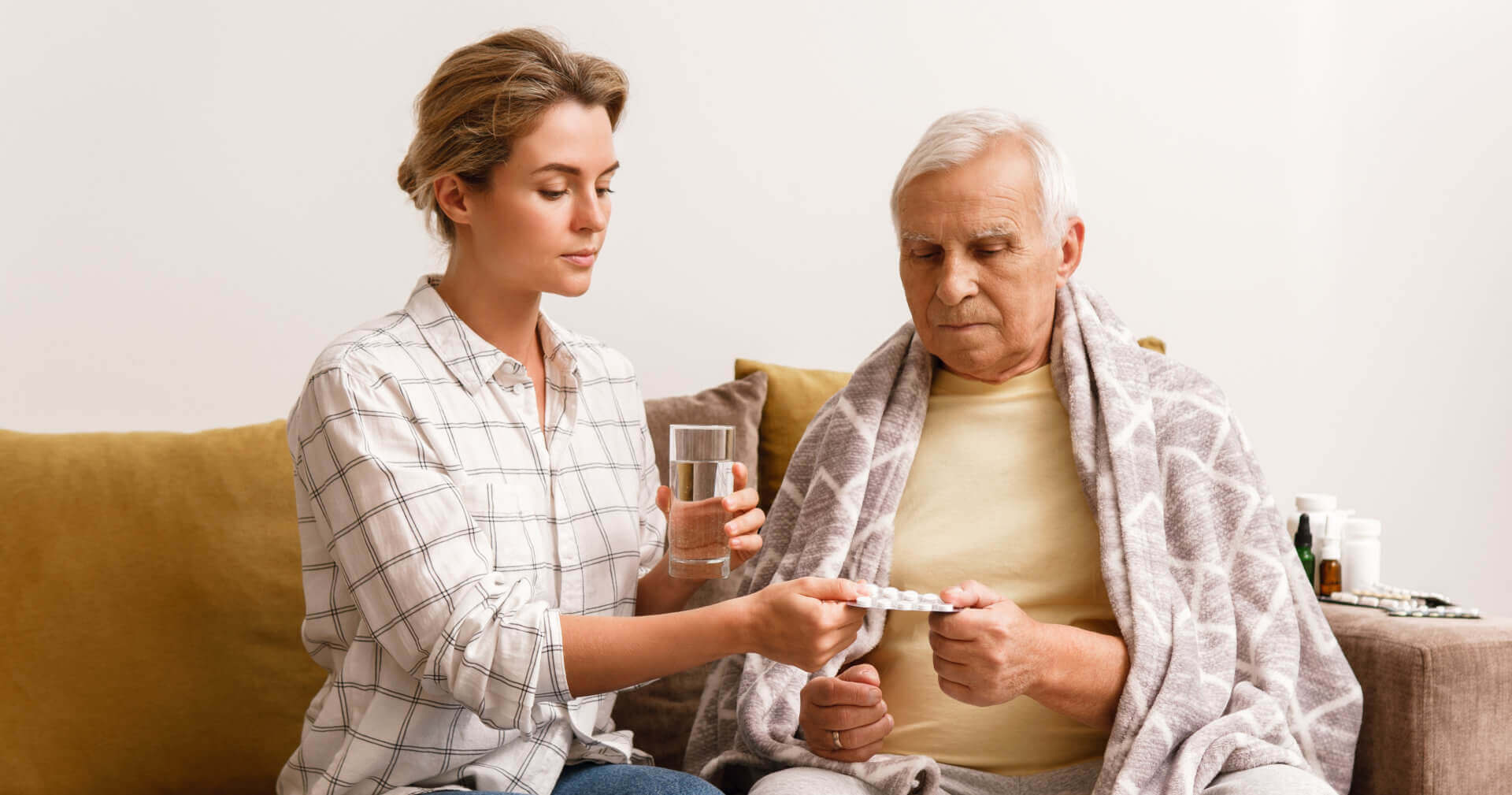 Aide giving a glass of water to a senior man